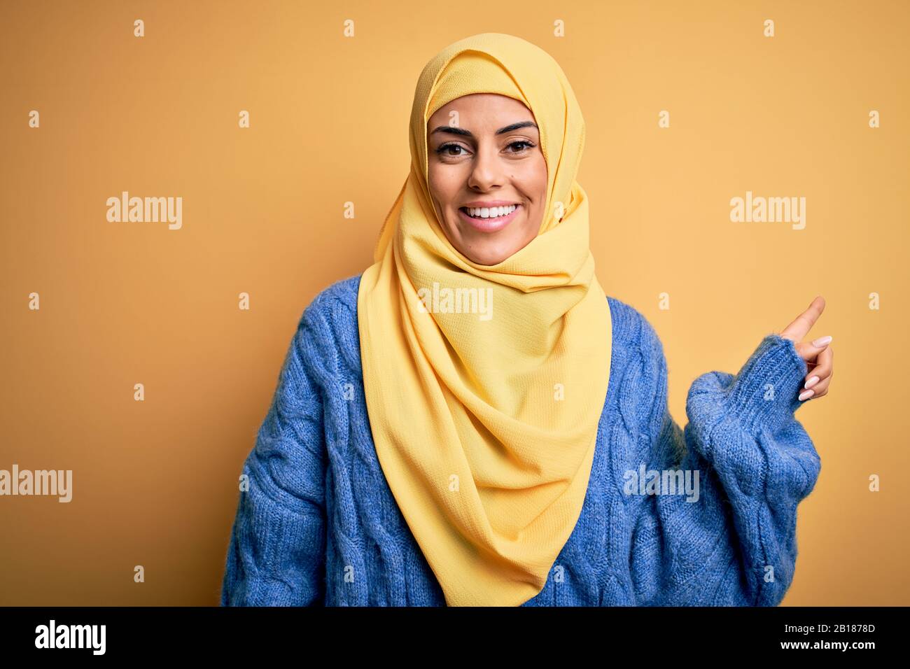 Young Beautiful Brunette Muslim Woman Wearing Arab Hijab Over Isolated Yellow Background With A Big Smile On Face Pointing With Hand Finger To The Si Stock Photo Alamy