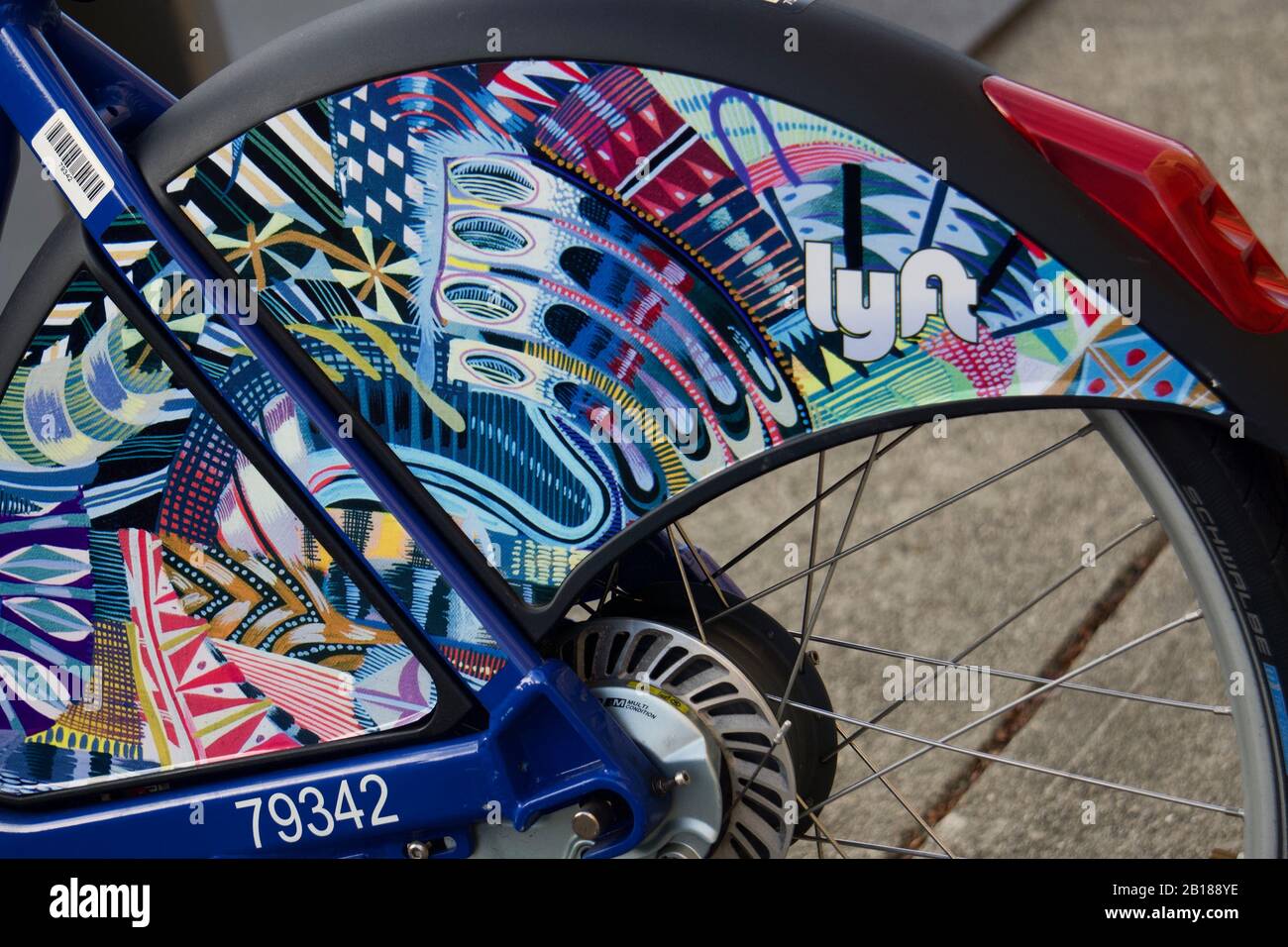 Parked public Lyft bicycle at bikeshare station with colorful back wheel coat guard. Sustainable carbon-free transportation option. Berkeley, CA Stock Photo