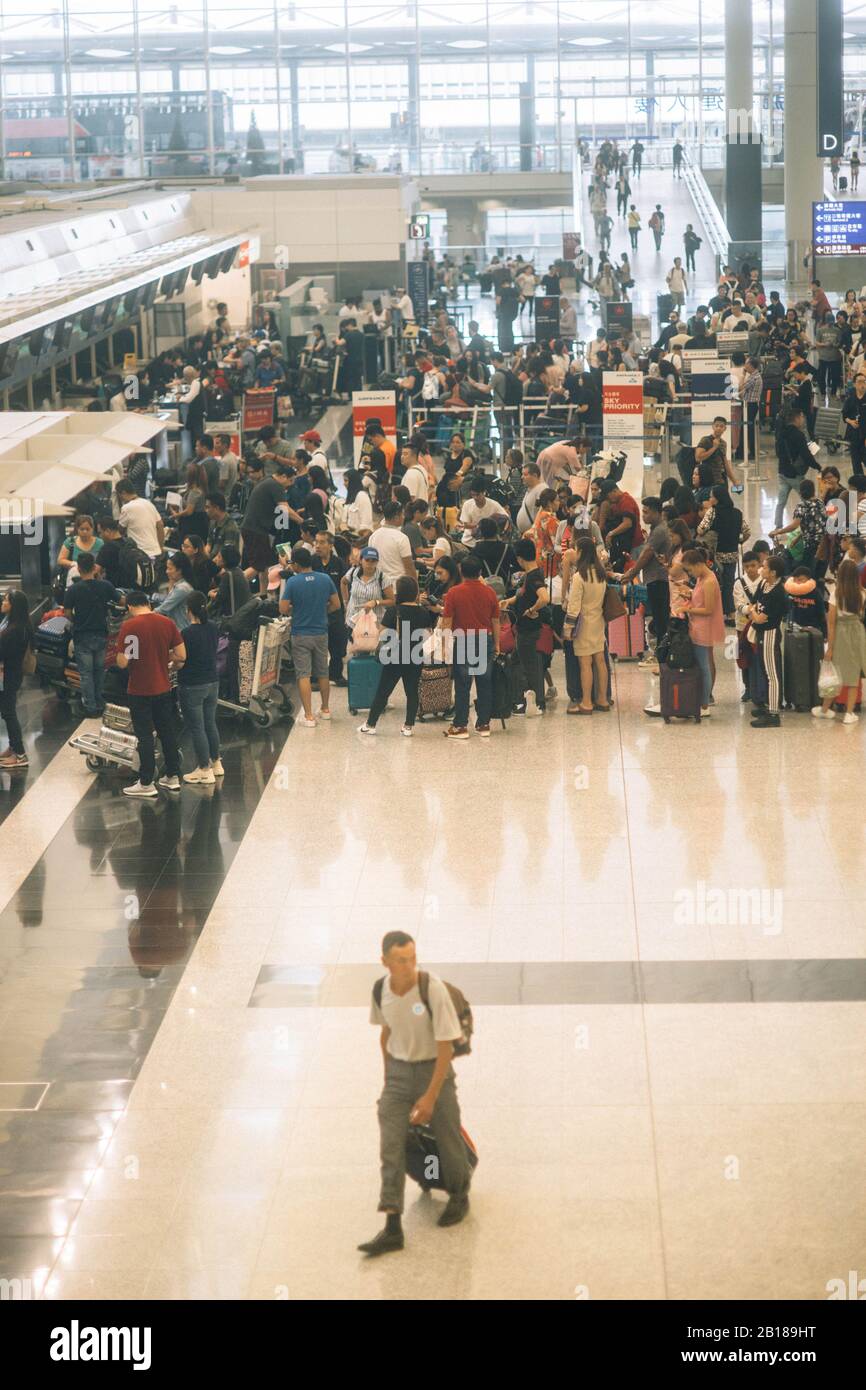 Crowded airport with check in queue in Hong Kong airport. Stock Photo