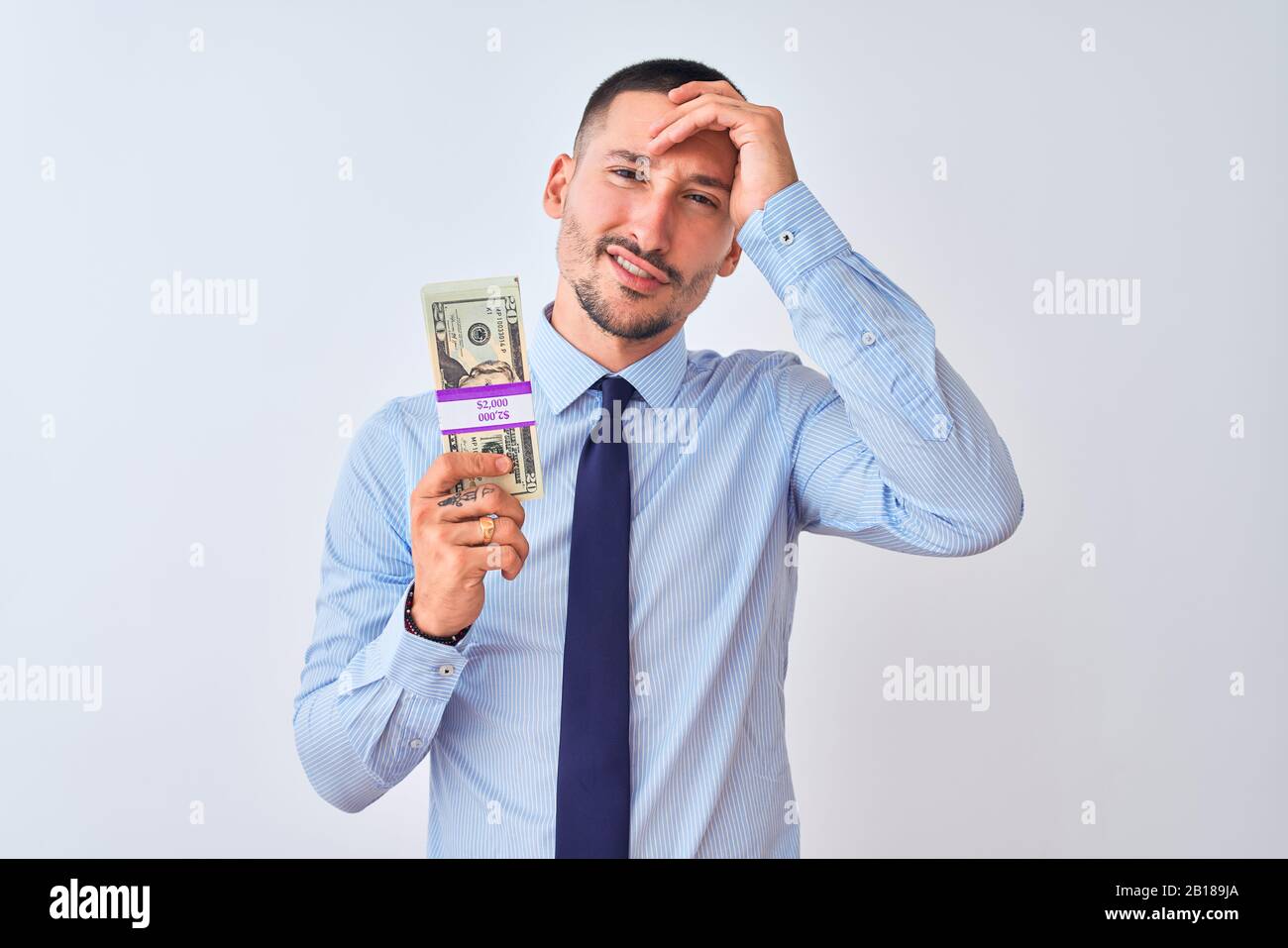 Young handsome business man holding a bunch of dollars bank notes over ...