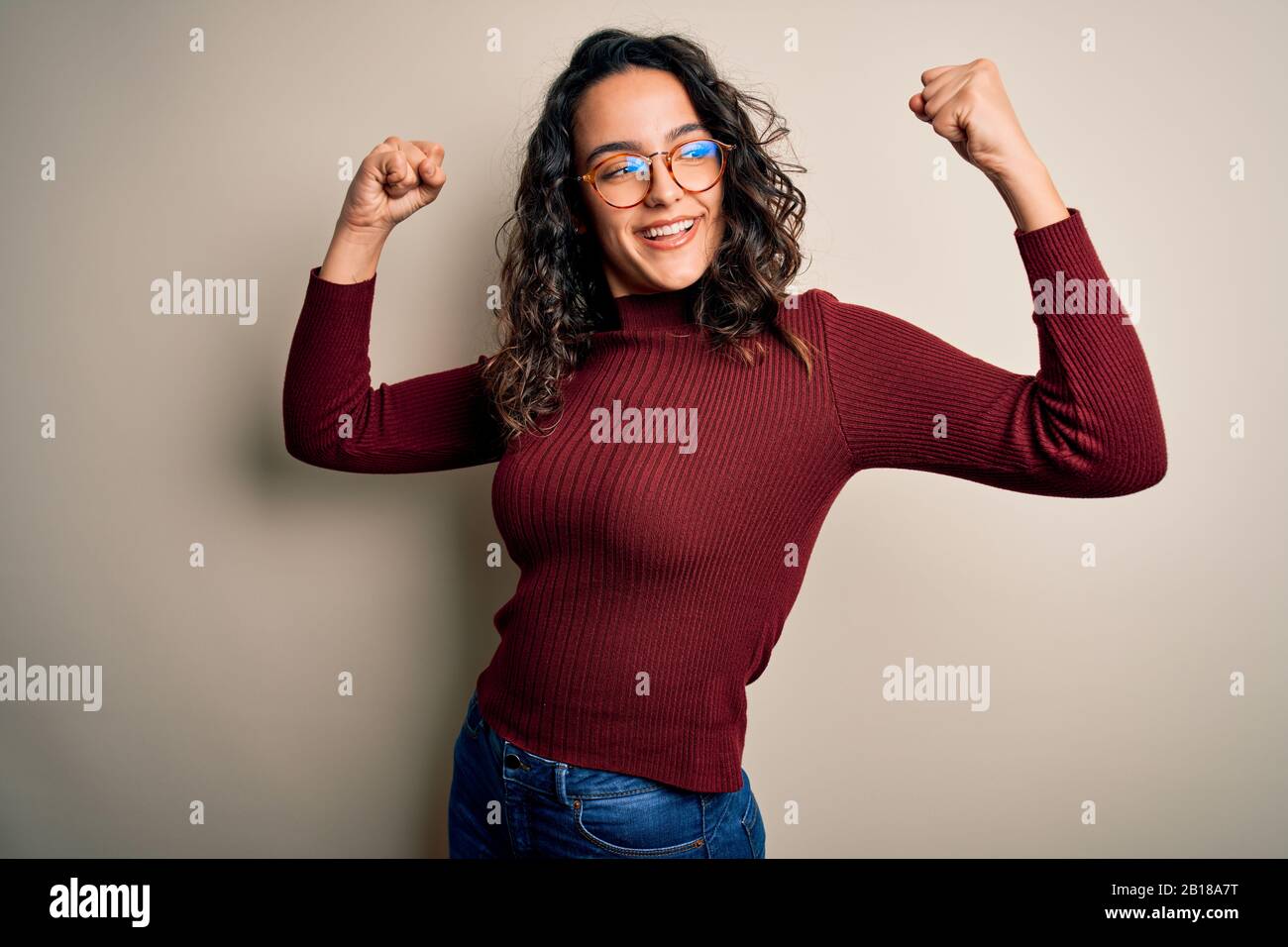 Beautiful woman with curly hair wearing casual sweater and glasses over ...