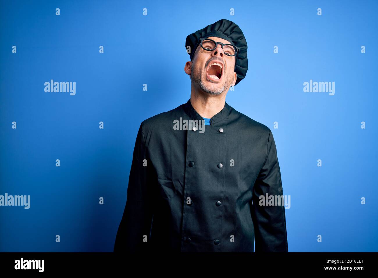 Young handsome chef man wearing cooker uniform and hat over isolated ...