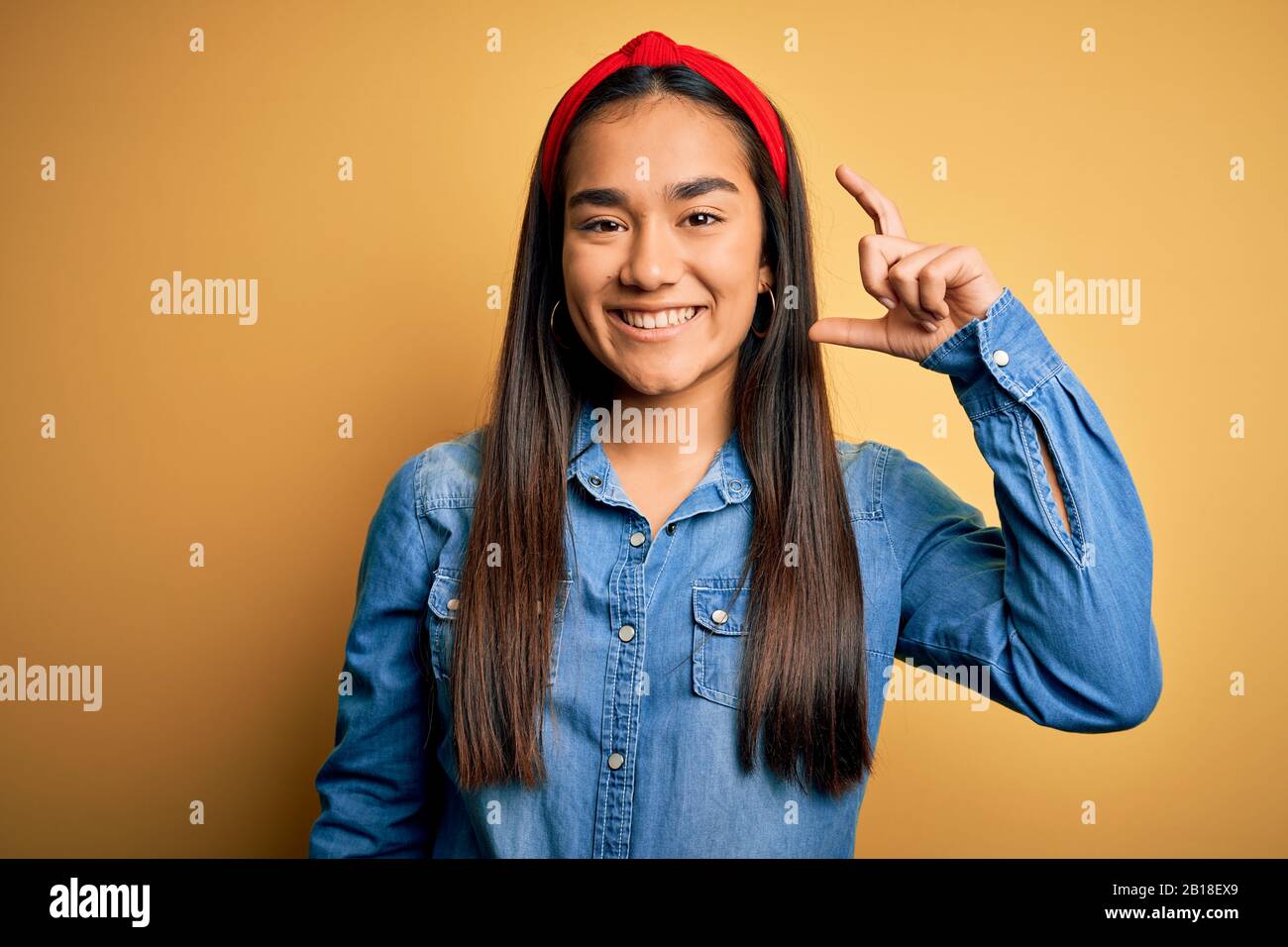 Young beautiful asian woman wearing casual denim shirt and diadem over ...