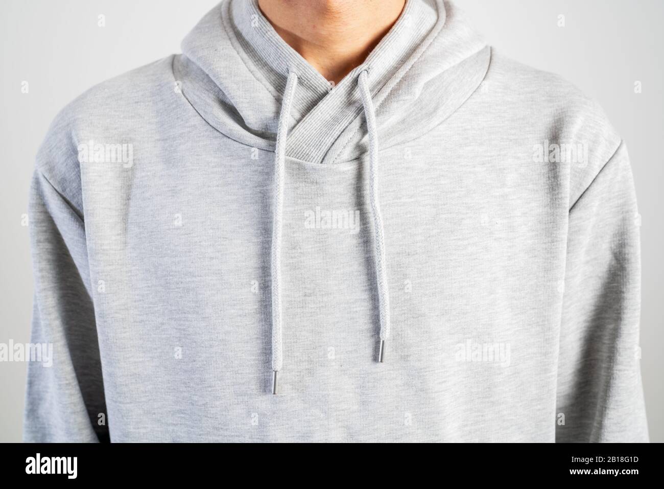 young person wear gray hoodie, sweatshirt mockup, isolated on white background Stock Photo