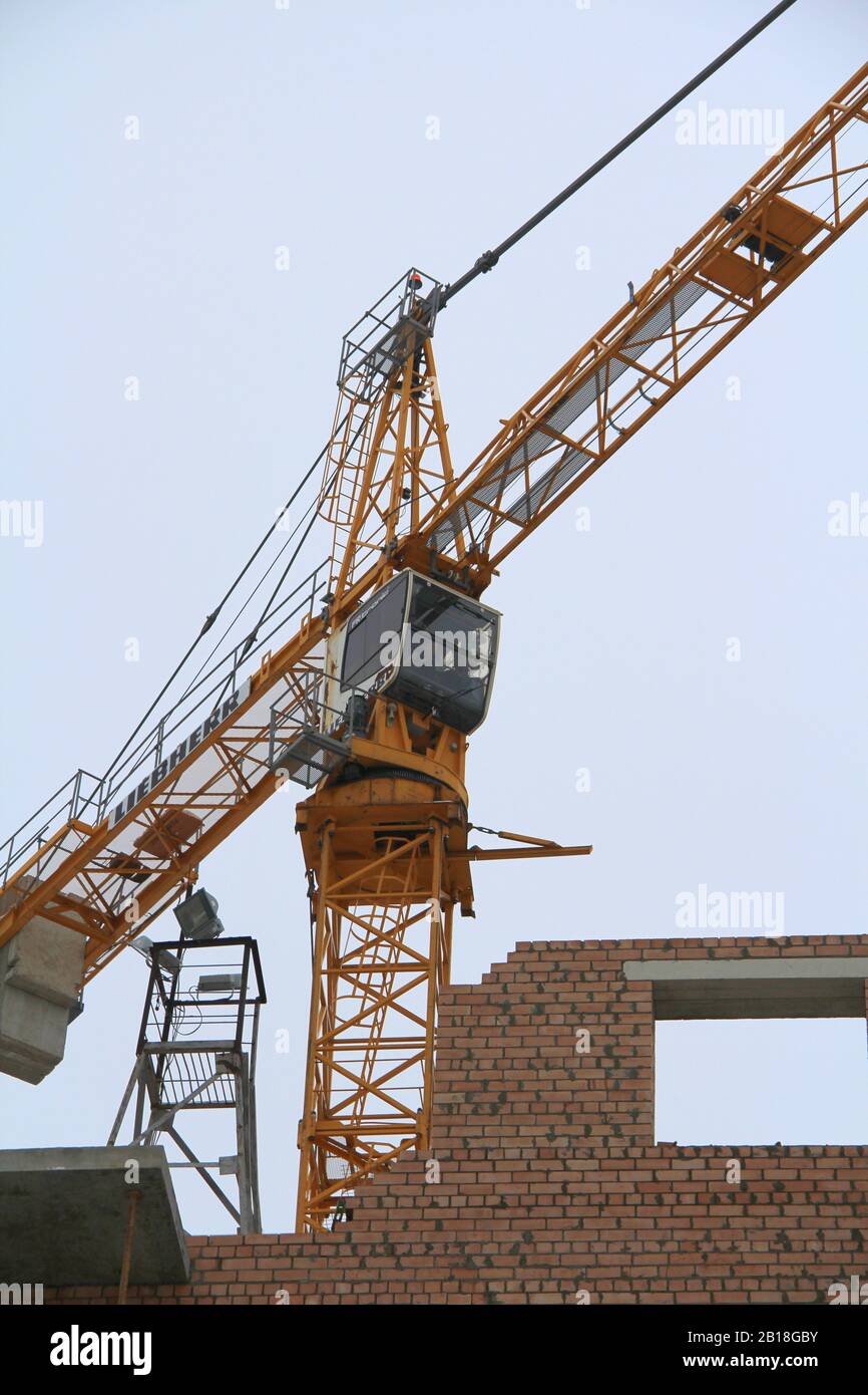 Tower crane works at a construction site against the sky. Crane driver's cab close up. Stock Photo