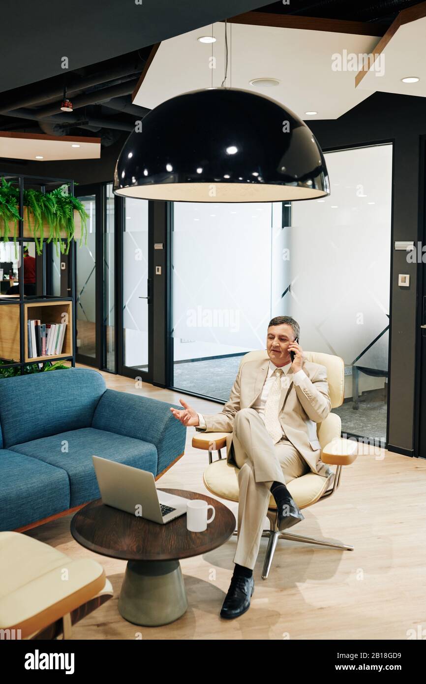 office lounge area on Confident Middle Aged Entrepreneur Sitting In Office Lounge Area And Talking On Phone With Client Stock Photo Alamy