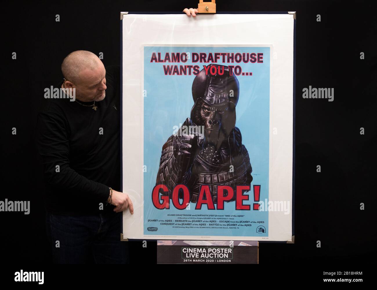 Prop Store poster consultant Mark Hochman looks at a Mondo poster for Alamo Drafthouse, which is part of a set of six posters for the Planet of the Apes movies (1968 - 1973) (estimate £500 - 700) during a preview for the Prop Store's forthcoming cinema poster auction. Stock Photo