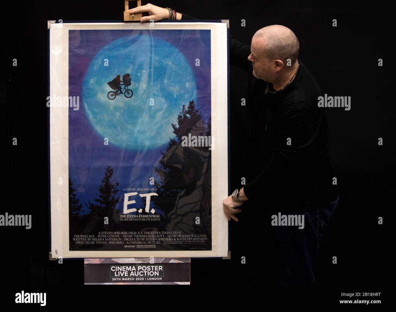 Prop Store poster consultant Mark Hochman looks at a US One-Sheet Poster for the 1982 film 'E.T, The Extra Terrestrial' (estimate £800 - £1,200), during a preview for the Prop Store's forthcoming cinema poster auction. Stock Photo