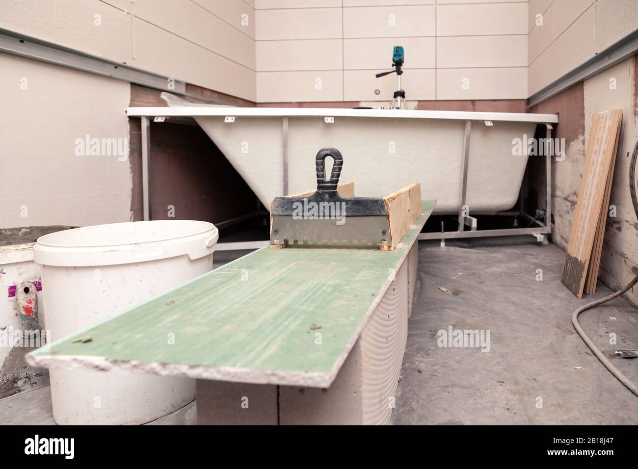 Bathroom interior, putty knife, dirty bucket, ceramic tiles, electronic