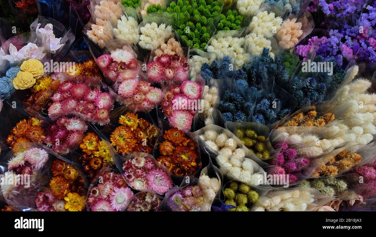 A variety of colorful flowers wrapped in transparent wrappers. View from above. Stock Photo