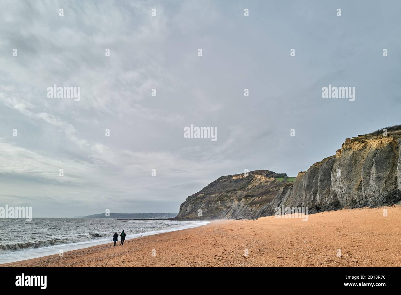 The shingle beach at Seatown, Dorset, by the English Channel with the cliffs of the Jurassic heritage coastline of England, on a sunny winter day. Stock Photo