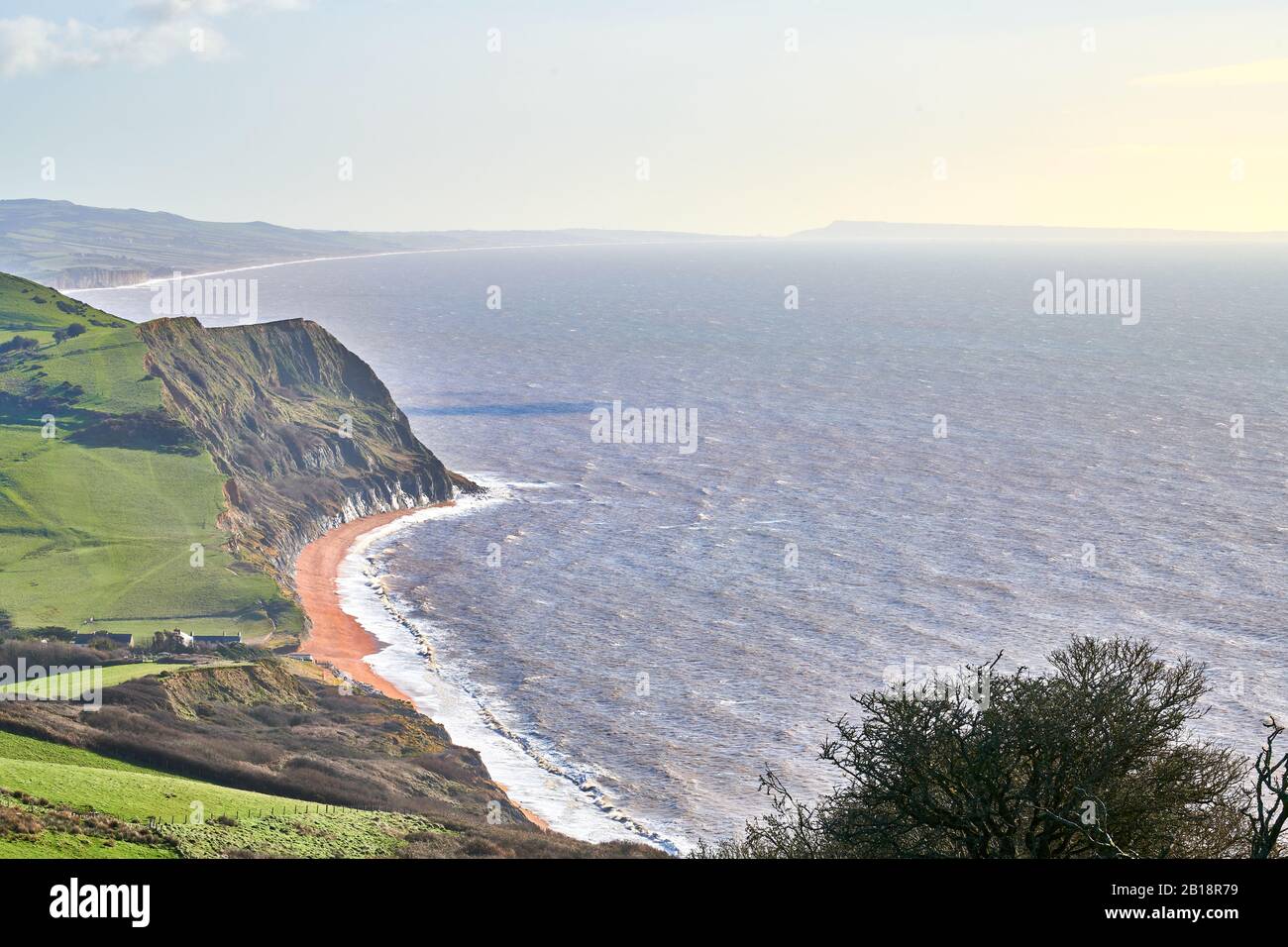 The shingle beach at Seatown, Dorset, by the English Channel with the cliffs of the Jurassic heritage coastline of England, on a sunny winter day. Stock Photo