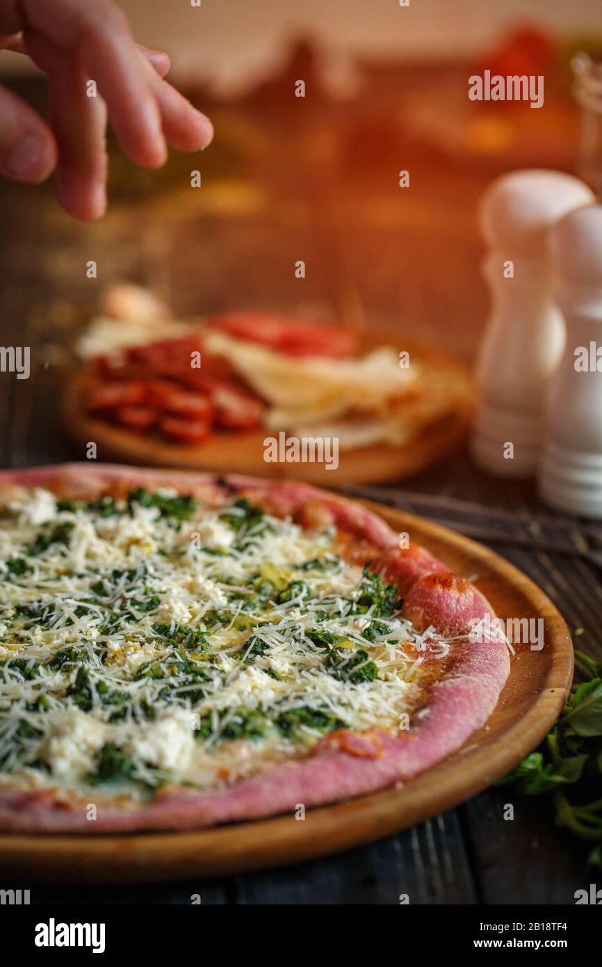 Chef's hand decorates a delicious hot pizza cheese. Stock Photo