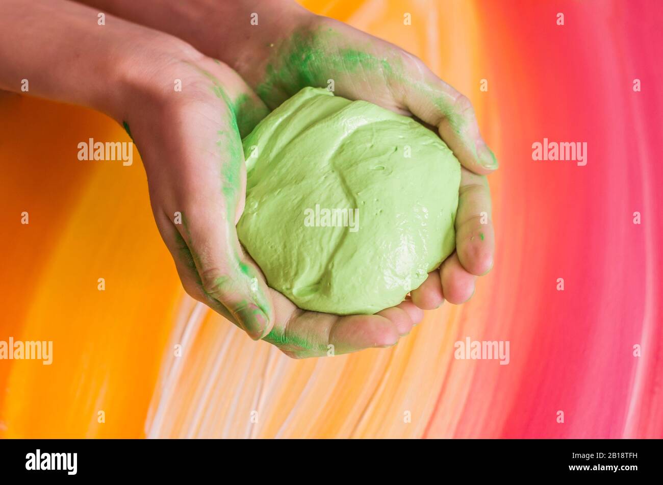 Light green slice in hands on a picturesque background. Toy for children photo. Stock Photo