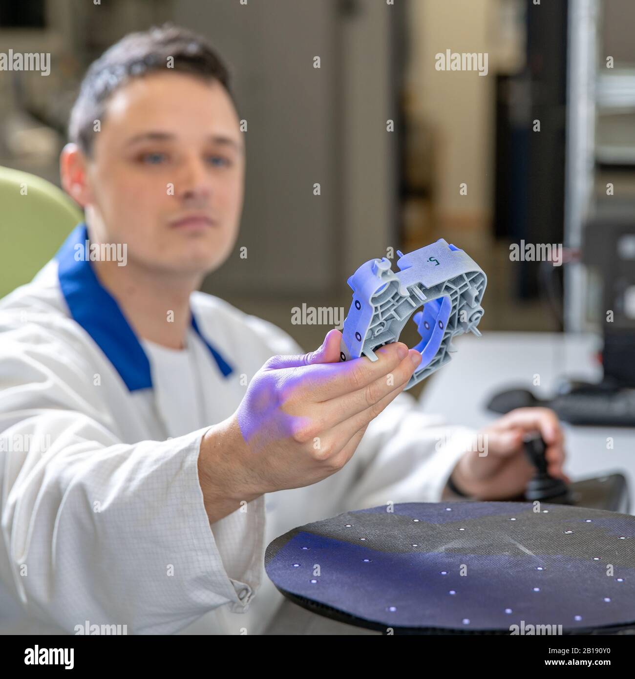 Quality engineer examines a sample scanned with a laser on a 3d scan in