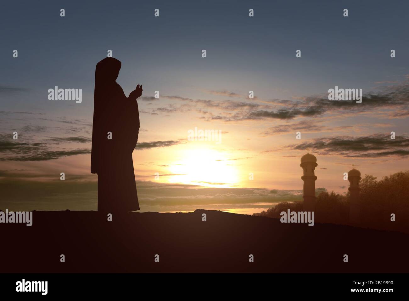 Silhouette of Muslim woman in a veil standing while raised hands and ...