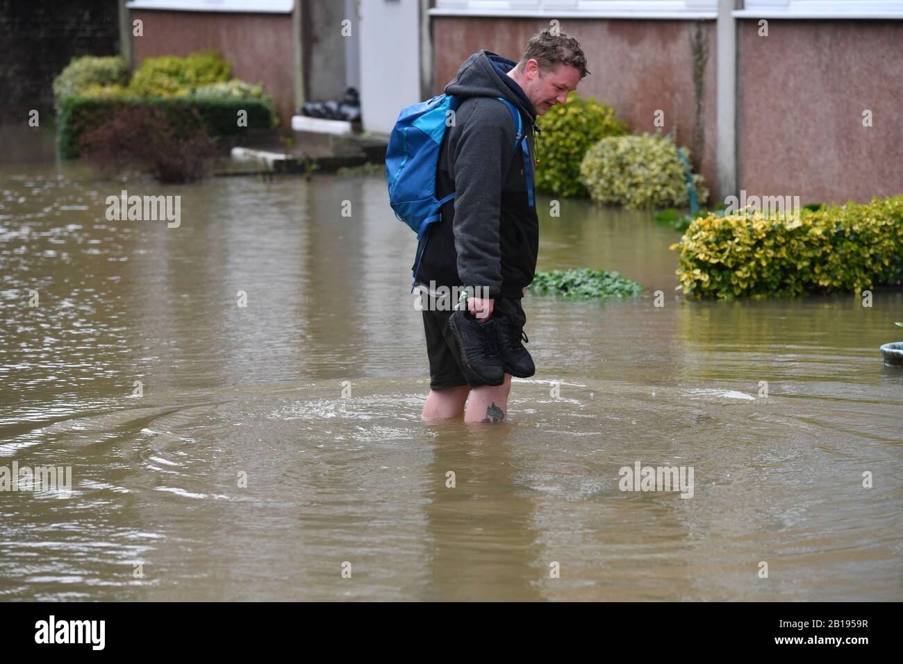 A man surveys the flooding in Berwick Road, Shrewsbury, near the River Severn, as warnings of further flooding are issued across the UK. Stock Photo
