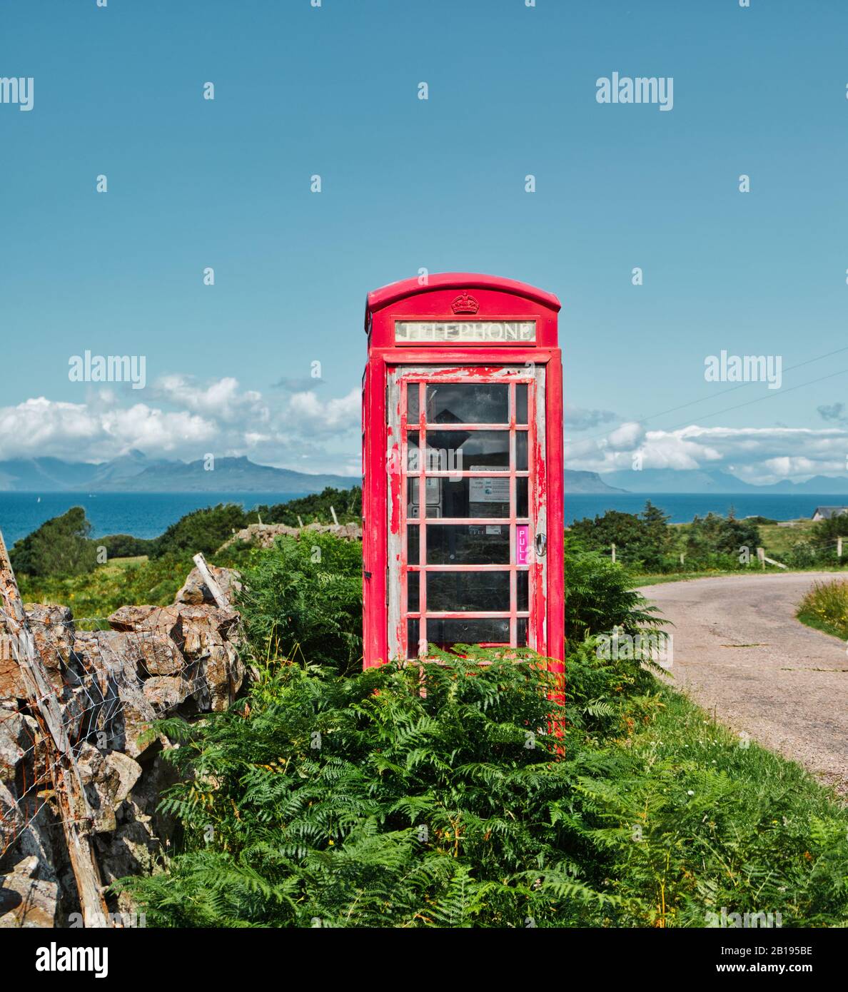 Traditional British iconic red remote telephone box and view of the Atlantic Ocean, Ardnamurchan Peninsula, Lochaber, Highland, Scotland Stock Photo