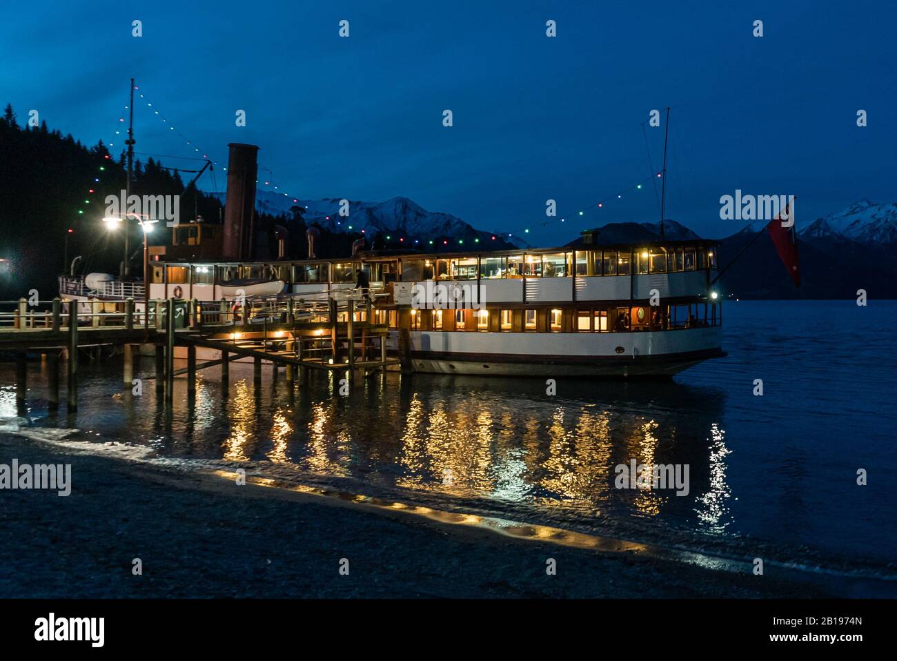 The Edwardian steamer TSS Earnslaw moored at Walter Peak High Country Farm on its evening cruise. Stock Photo