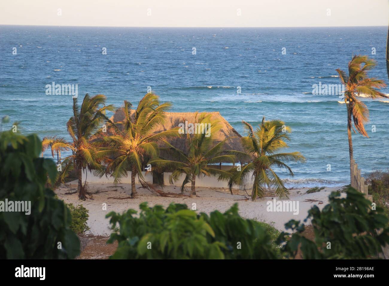 Cozy resort house with coconut trees on the shores of the Indian Ocean in Kenya. Diani Beach Stock Photo