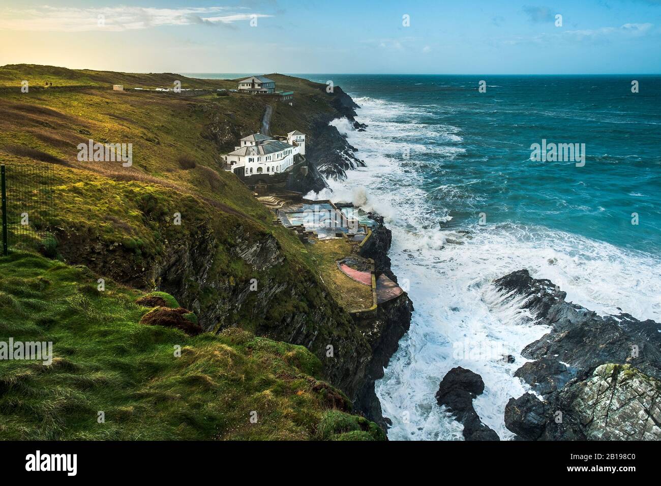 The large house Lewinnick Cove House known as Bakers Folly with the Lewinnick Lodge in the background on the rugged coast of Pentire Point East in New Stock Photo