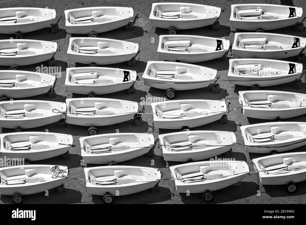 Aerial view of Optimist dinghies aligned. Sailing school boats in black and white Stock Photo