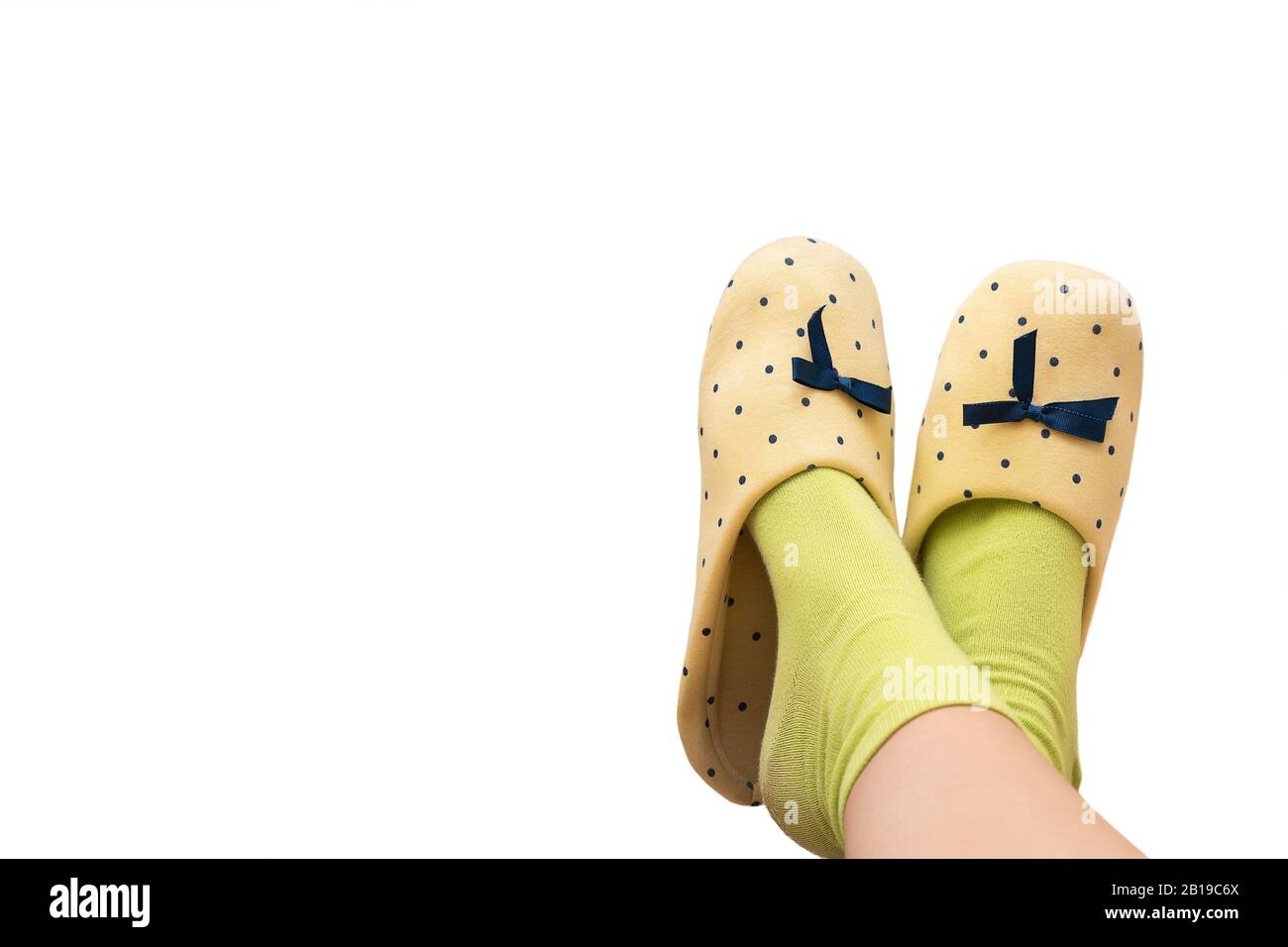 Female's feet with yellow slippers on white background Stock Photo