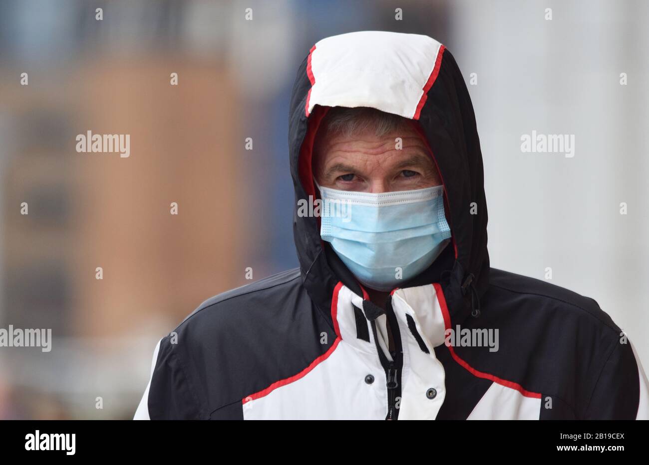 As more cases of the Coronavirus / Covid-19 are reported across the world including in Europe a man in the UK takes precautions by wearing a face mask Stock Photo