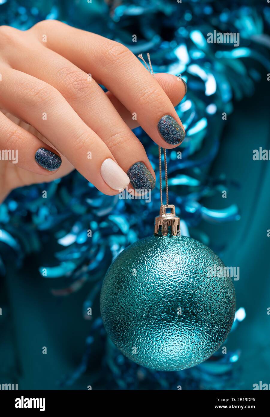 Beautiful female hand with blue christmas nail design. Stock Photo