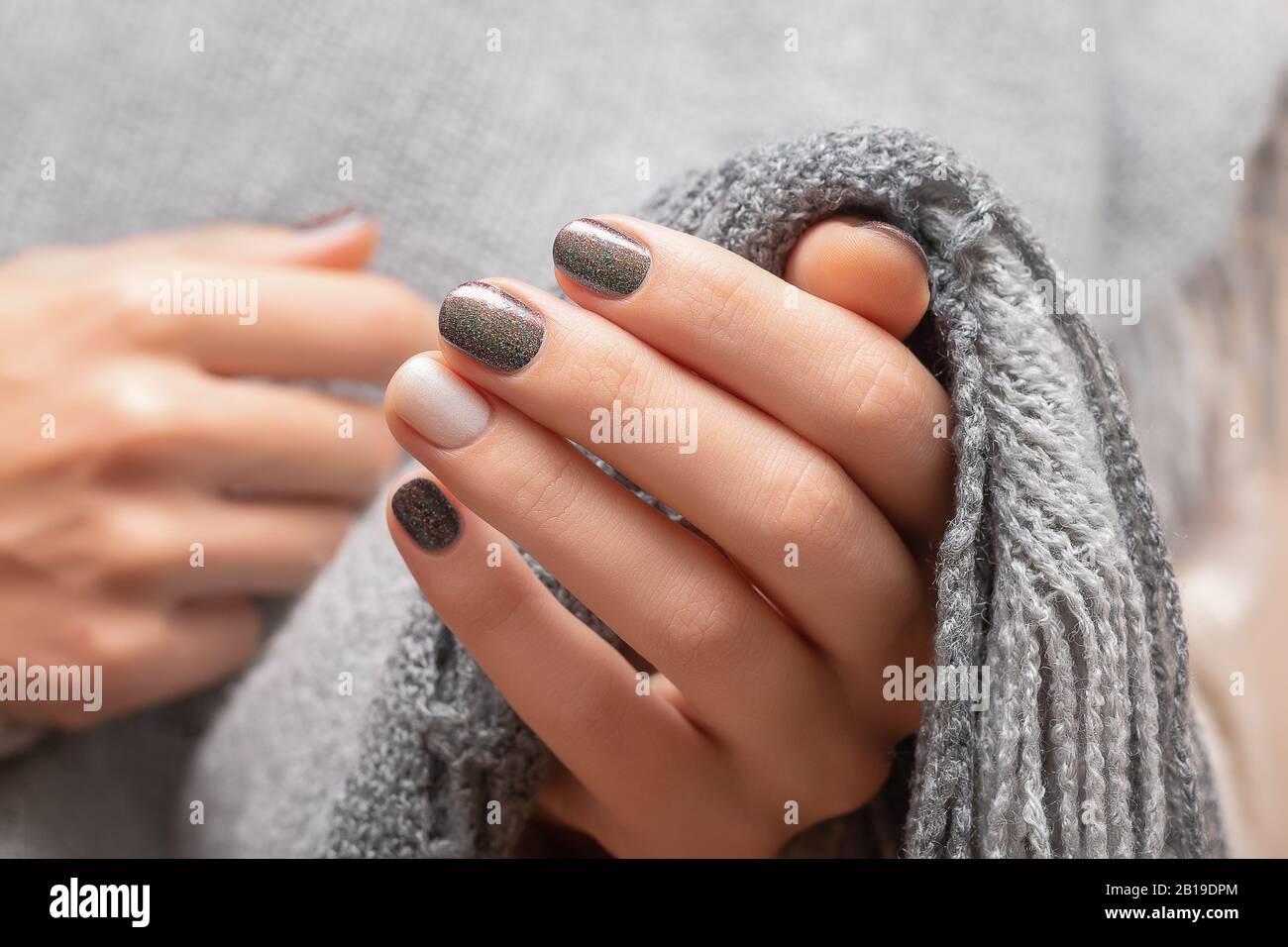Female hands with brown glitter nail design Stock Photo