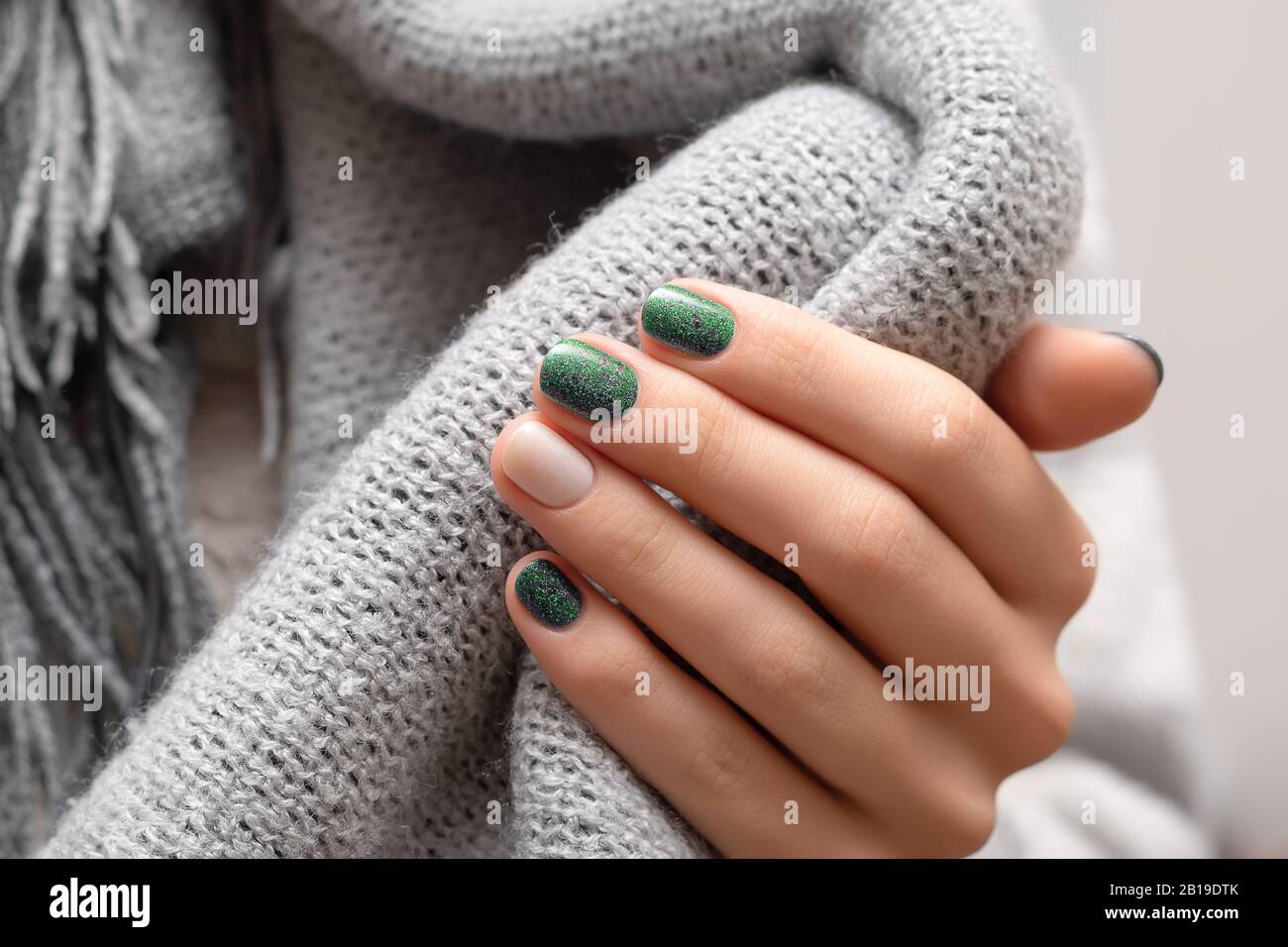 Female hand with green glitter nail design Stock Photo