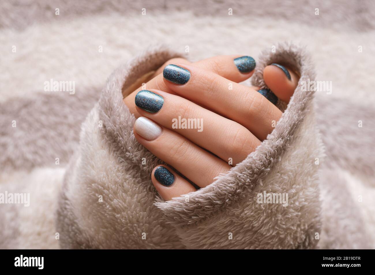 Female hands with blue glitter nail design Stock Photo