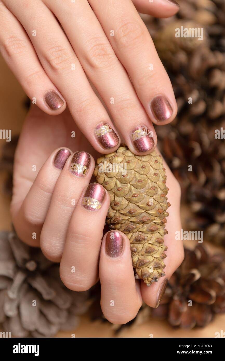 Female hand with brown glitter nail design holding pane cone Stock Photo -  Alamy
