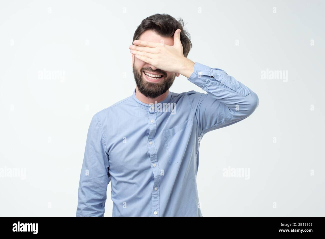 Young happy hispanic man screaming and covering eyes with hands ...