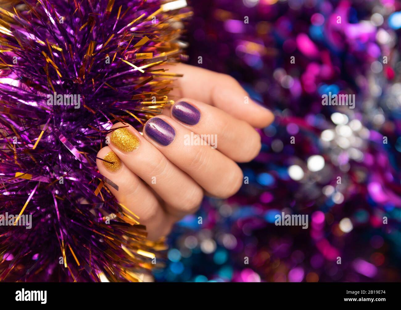 Beautiful female hand with purple christmas nail design. Stock Photo