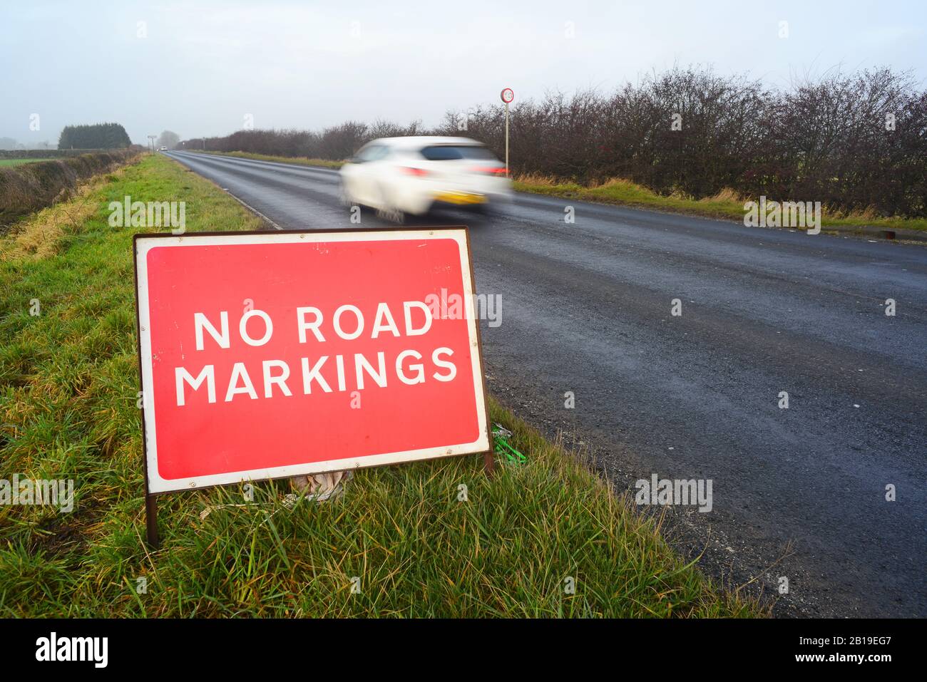 no road markings on road ahead warning sign after resurfacing leed yorkshire united kingdom Stock Photo
