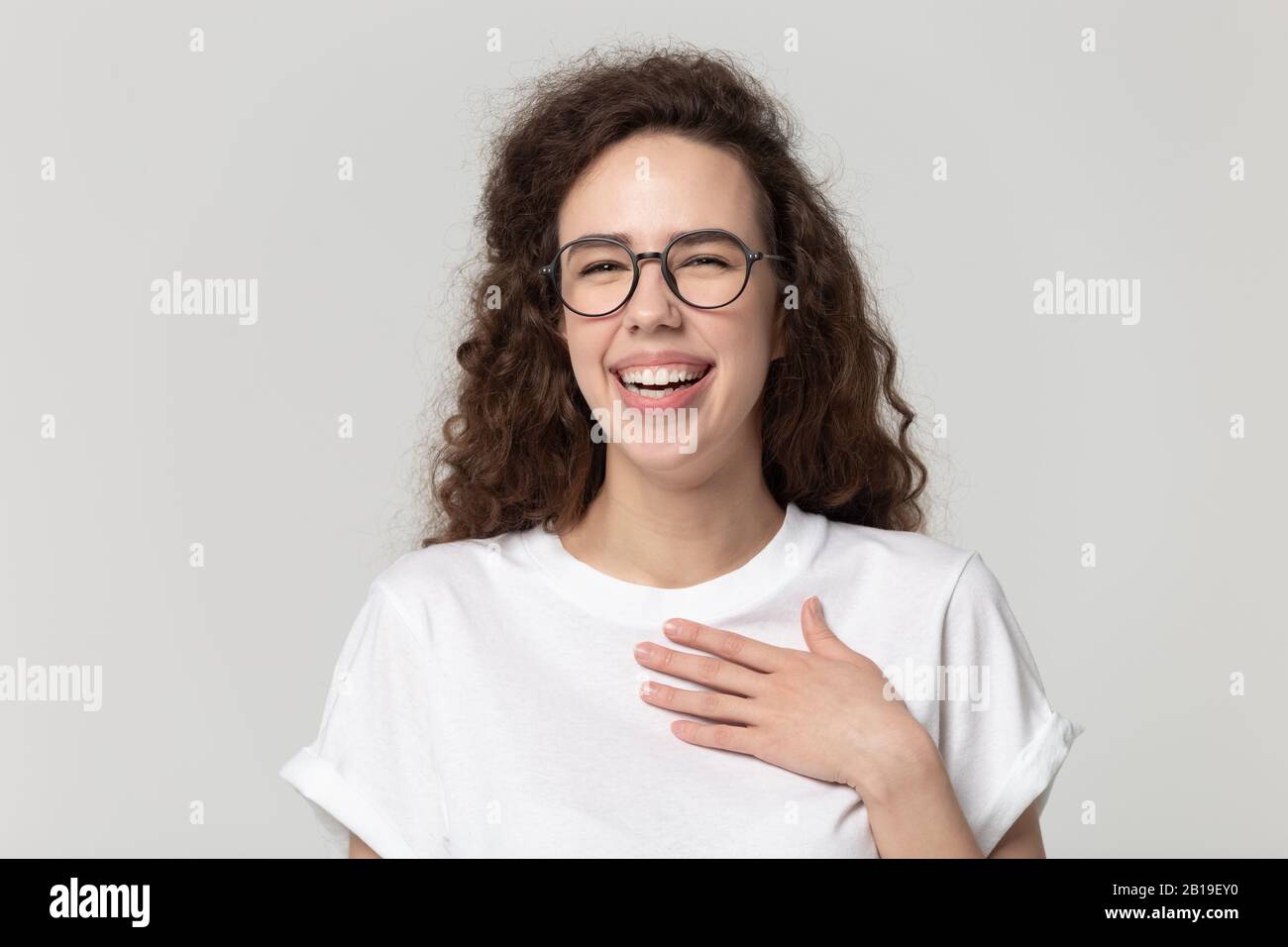 Cheerful pretty millennial woman in eyeglasses burst in laugh. Stock Photo