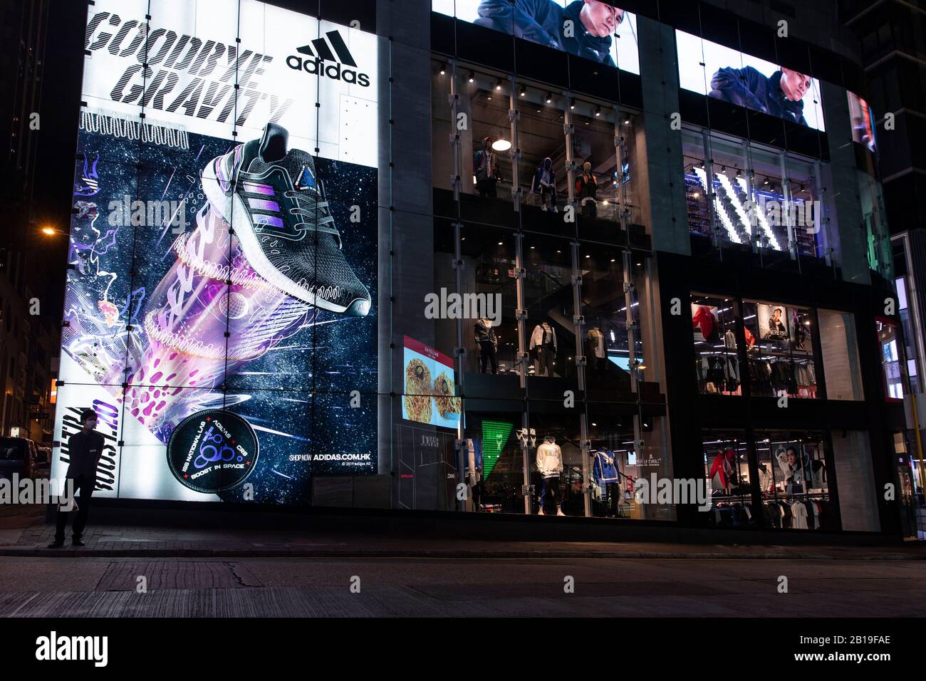 A pedestrian wearing a face mask walks past the Adidas store and logo in  Hong Kong.The deadly coronavirus (known as COVID-19) has caused most  industries, factories and malls in China shut down.