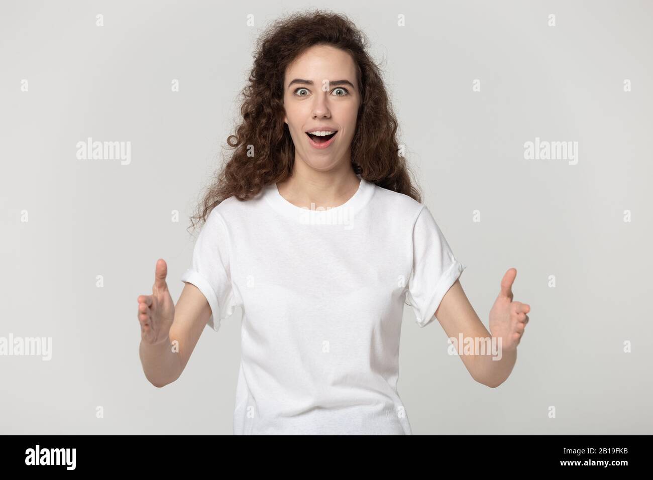Astonished attractive millennial woman showing big size. Stock Photo