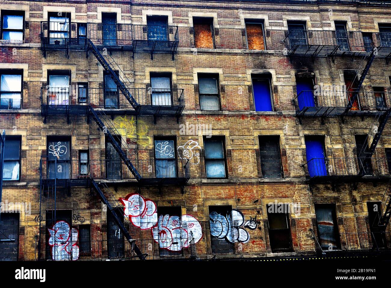 Old apartment block in Mid Town Manhattan, New York City , USA,featuring outer fire escape with graffitied walls. Stock Photo