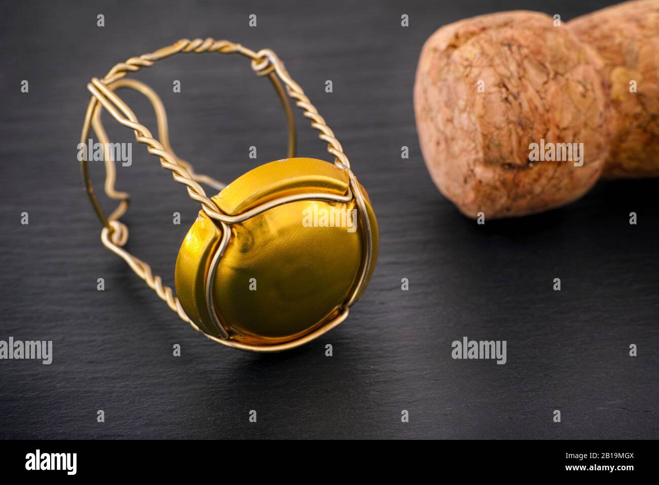 Champagne muselet with gold cap and cork on black stone background. Closeup Stock Photo Alamy