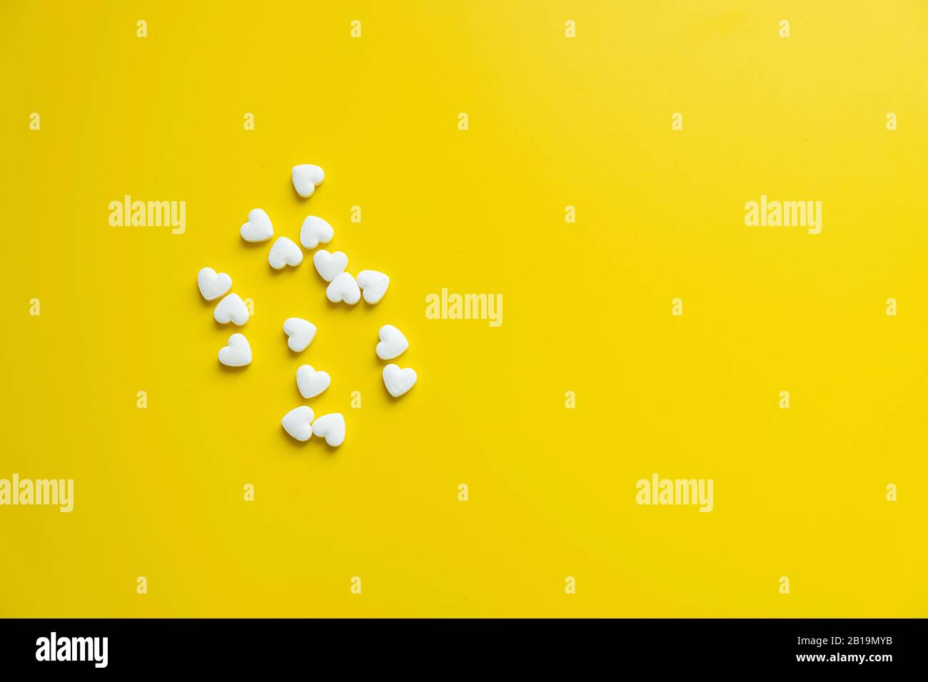 White cardiology pills on a yellow background minimalism, medicine concept Stock Photo