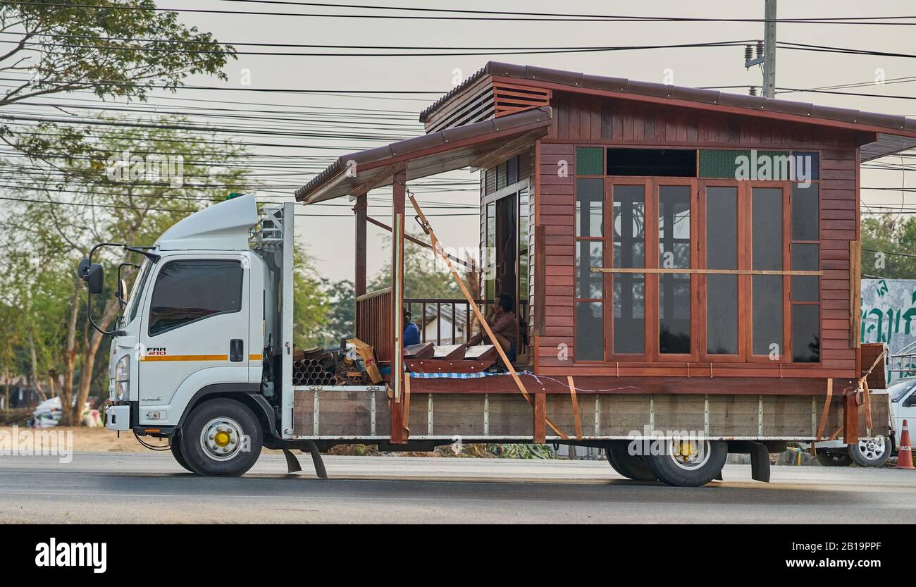 A small wooden house being transported on a truck. Stock Photo