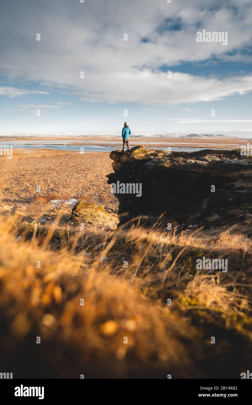 A young posing adventurous guy in a landscape of Iceland during the golden hour. Bucket list and Tourism in Iceland is worth your visit. Beautiful Stock Photo