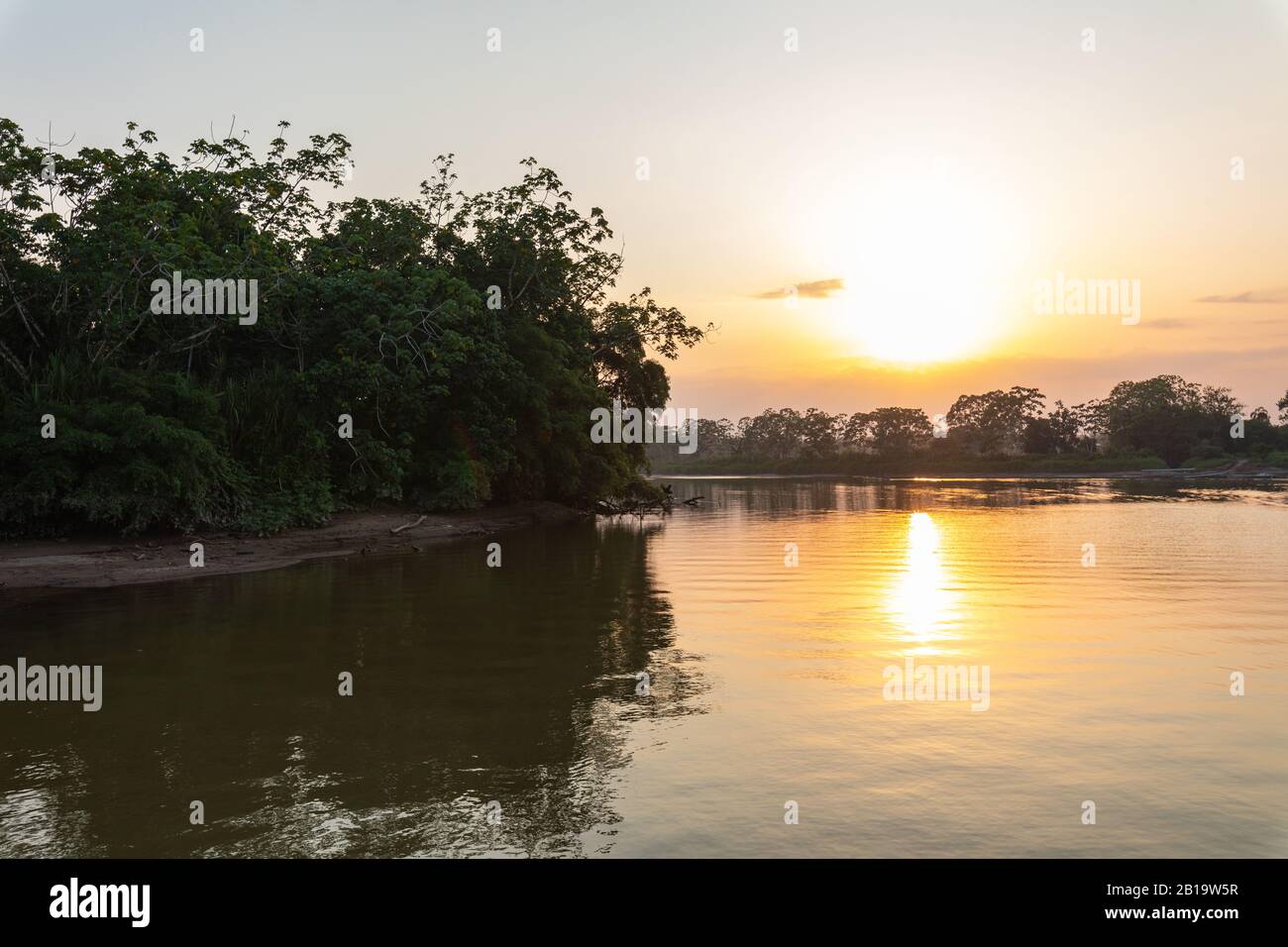 Amazon rainforest sunset during a boat trip with a reflection of the ...