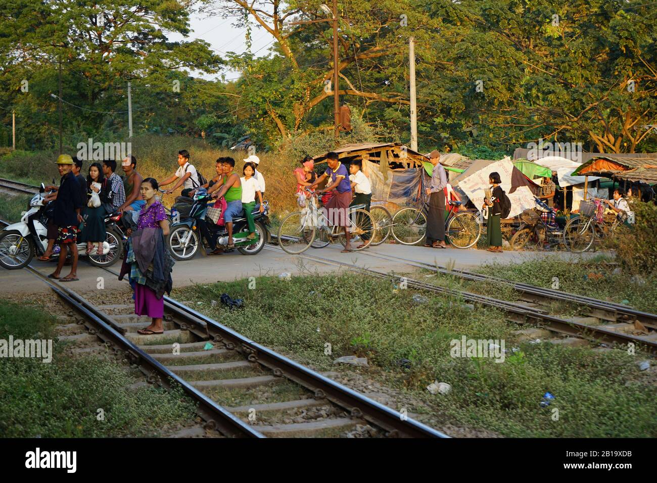 Menschen warten vor Bahnschranke, Zugstrecke von Yangon nach Mandalay, Myanmar Stock Photo