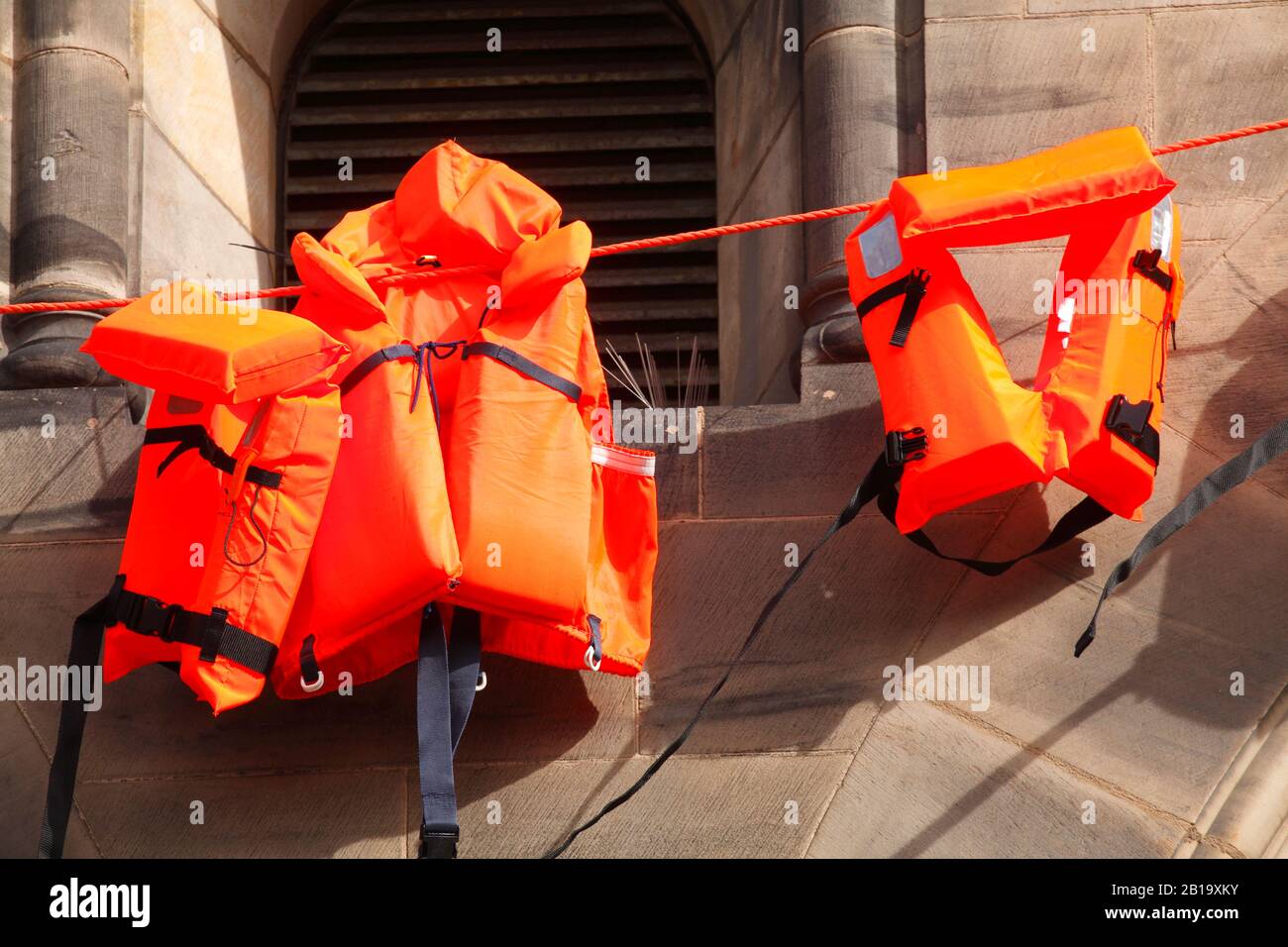 Orange life jackets as a memorial at Bremen Cathedral, Bremen, Germany Stock Photo