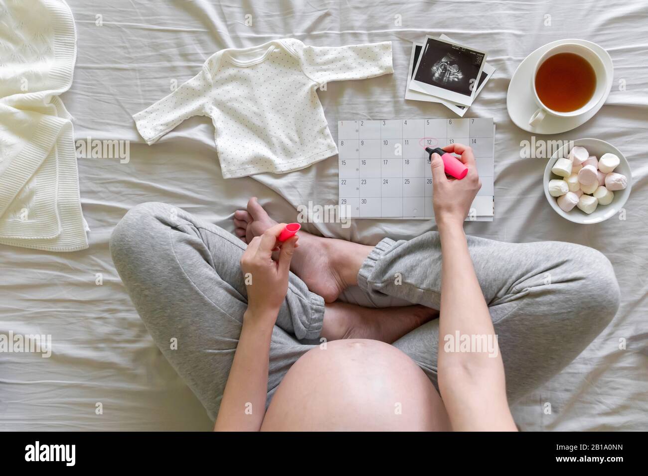 Top vew of expecting pregnant woman notes date of birth on the calendar, pregnancy and birth concept Stock Photo