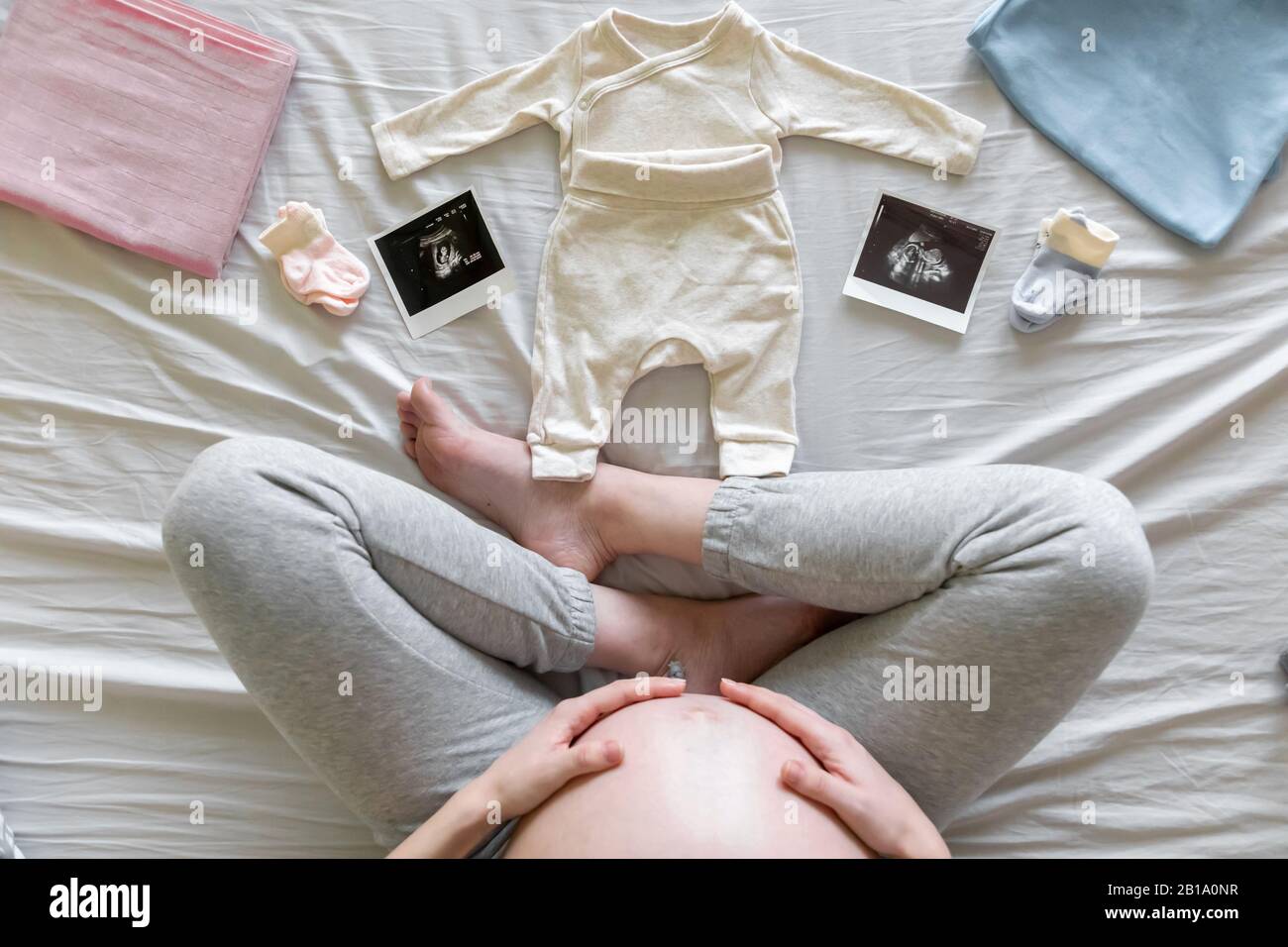 Top view of expecting pregnant woman in bed looking at ultrasound scans, boy or girl, pregnancy and birth concept Stock Photo