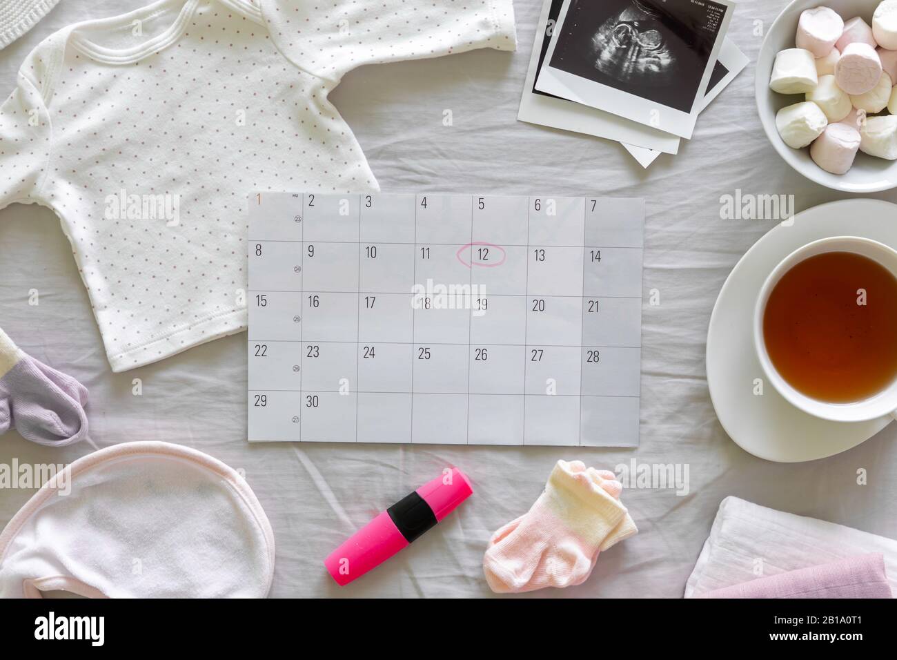 Calendar with the expected date of birth of baby, different baby clothes and ultrasound scan, pregnancy and birth concept Stock Photo